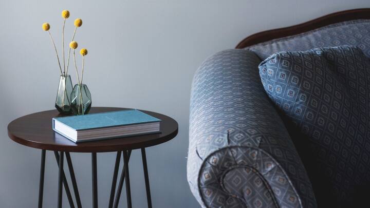 4. Use Wooden Side Tables: Functional yet also eye-catching, sturdy side tables are another must bring item that every minimalist is bound to incorporate in their wooden themed living room. Grab a couple of light toned wooden items and even build a custom one to serve as a setting for modest decor and to sit your books, and winter drinks on. (Image Source: Canva)