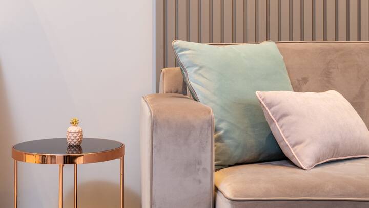 1. Pick Minimalist Wooden Furniture: A coffee table unit, bookshelves or even a TV unit built from a combination of light oak over walnut can feature clean cut minimalist lines that invite warmth into the living area while retaining a modern feel to the place. Additionally, neutral toned cushions can be placed onto the furniture, to retain a soft and inviting appeal. (Image Source: Canva)