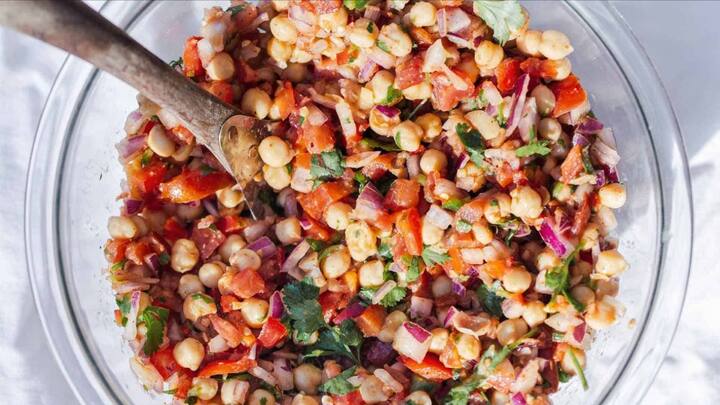 5. Chana Chaat: Chana Chaat is an Indian snack that's made with boiled chickpeas, onions, tomatoes, and spices. This flavourful snack also offers nutrition along with tangy and spicy flavours. It's garnished with lemon juice, green chillies, and coriander leaves. (Image Source: Pinterest/FreshFlavorful)