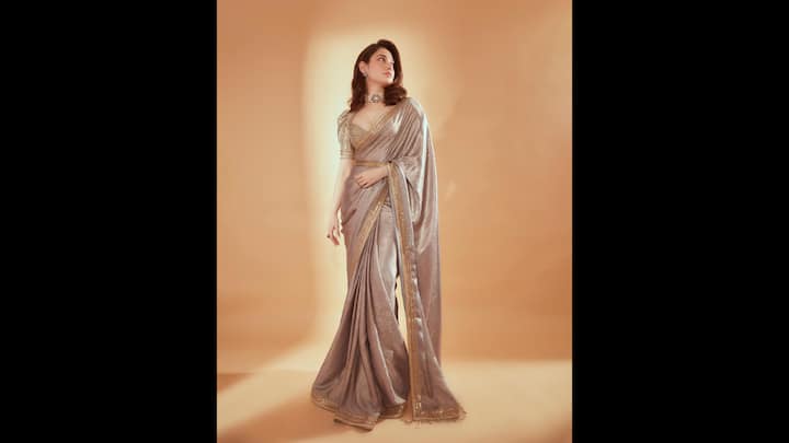 4. Tamannaah Bhatia: Tamannaah Bhatia's unique grey saree paired with a statement leg of mutton sleeve blouse gave her a striking look. The traditional saree had intricate border detailing along the edges that added a touch of grace, The brocade blouse with a plunging neckline enhanced the regal appeal of the outfit. She paired her saree with a pearl choker and delicate floral stud earrings that elevated her royal look. (Image Source: Twitter/@kerala9)