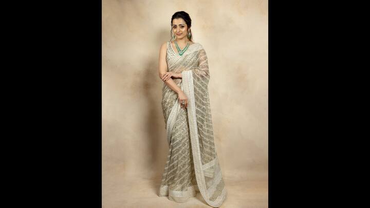 7. Trisha Krishnan: Trisha Krishnan wore an ivory handcrafted saree that had delicate studded detailing and intricate embroidery. The sheer net saree featured exquisite detailing throughout the elevated the look. She paired her look with a matching sleeveless blouse with a deep V neckline. To add a contrasting touch, the actress accessorised with green jewellery that balanced traditional with modern grace. (Image Source: Twitter/@VCinemaLive)