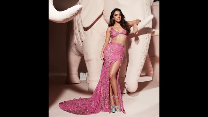 3. Pink Embellished Lehenga: Kiara Advani wore a pink lehenga that had shimmering sequins and intricate beadwork detailings. To elevate her look, she wore beautiful silver platform heels. The thigh high slit and the trailing fabric gave the actress a dramatic look. (Image Source: Twitter/@vamsikaka)