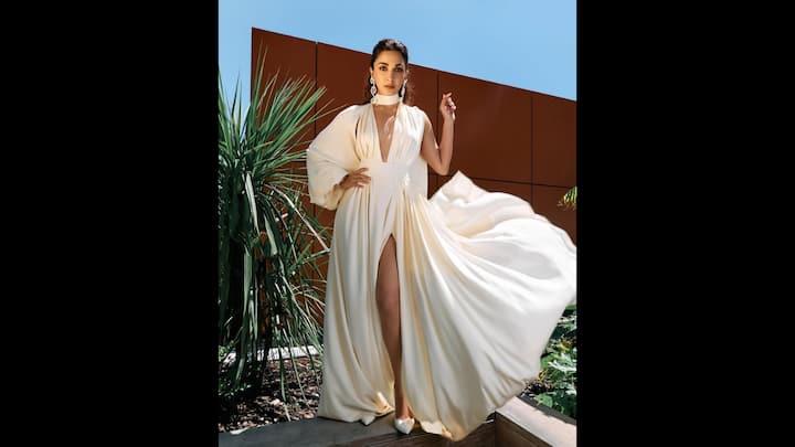 2. Voluminous White Gown: Kiara Advani served a statement look in her flowing white gown that had a plunging neckline, dramatic thigh high slit, voluminous sleeves, and a choker style neckline. The delicate fabric gave the actress an elegant look. The actress completed her look with a matching white heels and statement pearl earrings that exuded modernity. (Image Source: Instagram/@kiaraaliaadvani)