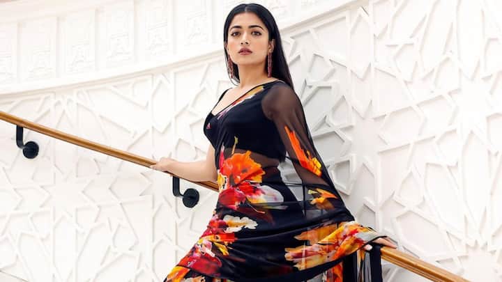 Rashmika wore a black georgette saree that featured vibrant yellow, pink, white, and orange floral prints. She adorned the look with a beautiful black sleeveless blouse, which had a cutout back and a plunging neckline, a perfect touch of modern elegance. (Image Source: Instagram/ rashmika_mandanna)