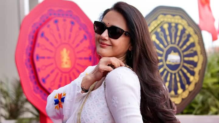 Preity Zinta looks graceful in this Anarkali worked in white teamed with a floral dupatta. Black glasses, silver hoops, and a small bindi complete the outfit with a hint of a modern and traditional touch. (Image Source: Instagram/ realpz)