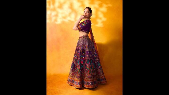 5. Vibrant Traditional Look: The beautiful vibrant traditional multicoloured lehenga gave Tamannaah Bhatia an alluring look. The ethnic outfit featured vibrant colours, floral patterns, and embellishments that enhanced the aura of the fit. To complete her outfit, she wore a matching net dupatta and gold jewellery. (Image Source: Instagram/@tamannaahspeaks_)