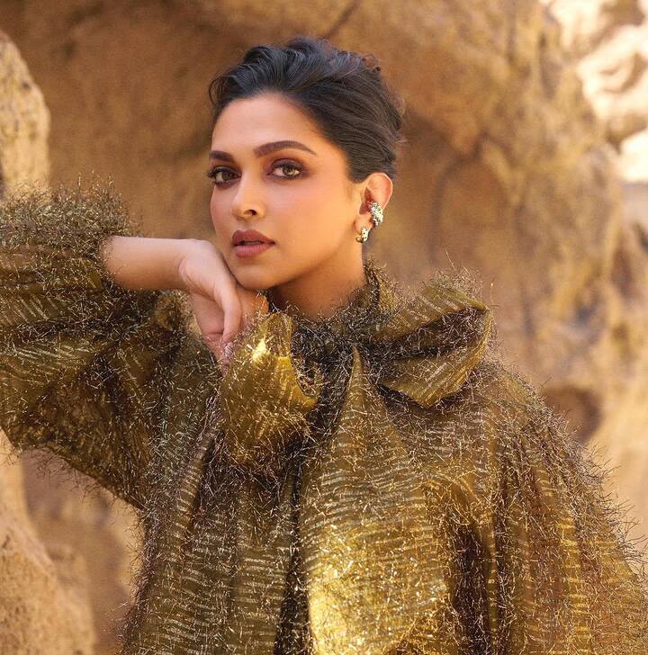 She accessorized with mixed metal earrings and rings by Cartier, completing the look with a messy French knot, subtle smokey eyes, mauve pink lips, and a glowing highlighter.