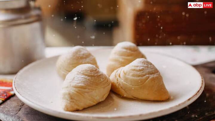 आटे को आराम देने के बाद, इसे छोटे-छोटे हिस्सों में बांट लें और हर हिस्से को एक बॉल की तरह बेल लें. बेलन की मदद से हर बॉल को एक छोटे, पतले गोले में बेल लें. हर गोले के बीच में एक चम्मच भर भरावन रखें. आटे को आधा चांद जैसा आकार देने के लिए भरावन के ऊपर मोड़ें.