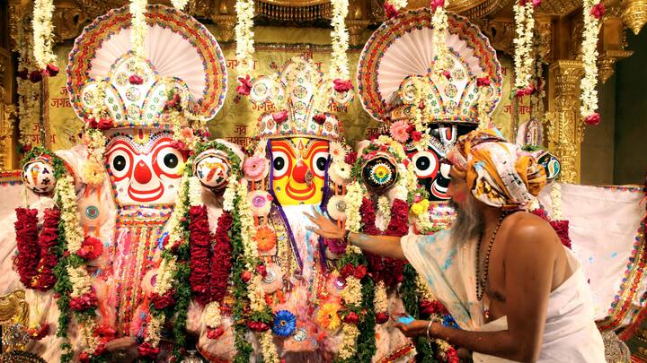 Ahmedabad: A priest applies 'gulaal' to deities during Holi celebrations at the Jagannath Temple. (Image Source: PTI Images)