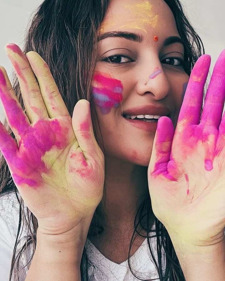 Sonakshi's forehead is seen in the photos. He has a red-yellow color on his face and his hands are also painted in pink.