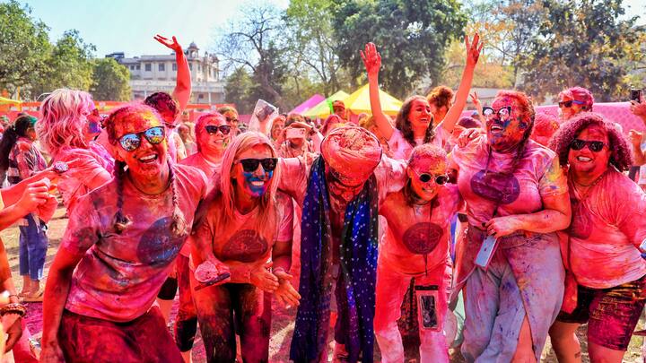 Jaipur: Tourists pose for photographs during the Dhulandi festival celebration organised by Rajasthan Tourism at Khasa Kothi. (Image Source: PTI Images)
