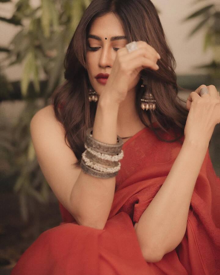 Chitrangda's look is defined by a deep red saree with delicate embroidery, exuding a classic yet contemporary appeal. The rich fabric drapes beautifully over her silhouette, enhancing her ethereal grace.