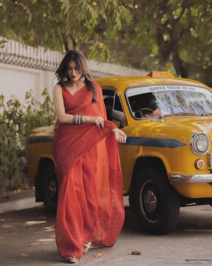Draped in a stunning red saree, she effortlessly blends old-world charm with modern sophistication.