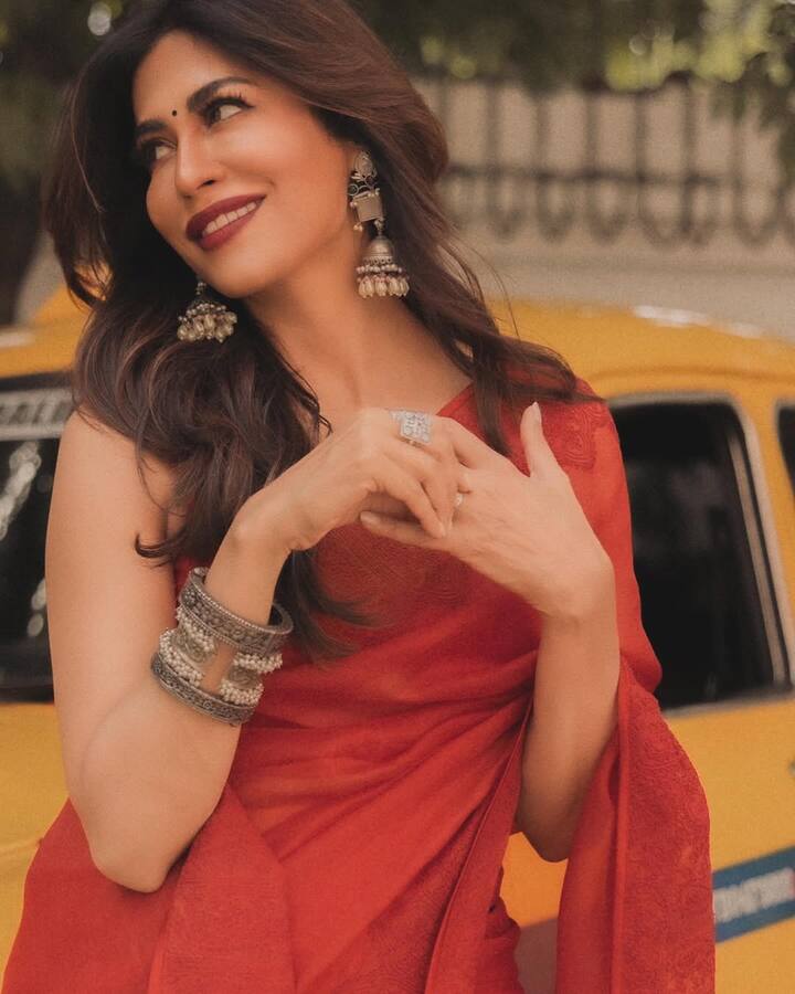 Complementing her attire, she accessorizes with oxidized silver bangles stacked on her wrist, statement jhumkas, and intricately designed rings, adding a bohemian yet regal touch.