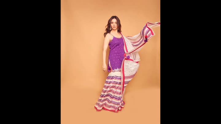 4. Tamannaah Bhatia: Tamannaah Bhatia wore a vibrant purple spaghetti kurta and paired it with a white sharara which had striped patterns. The flowing and matching dupatta added a charm that made the outfit an idea choice for festive gatherings. (Image Source: Instagram/@tamannaahspeaks)