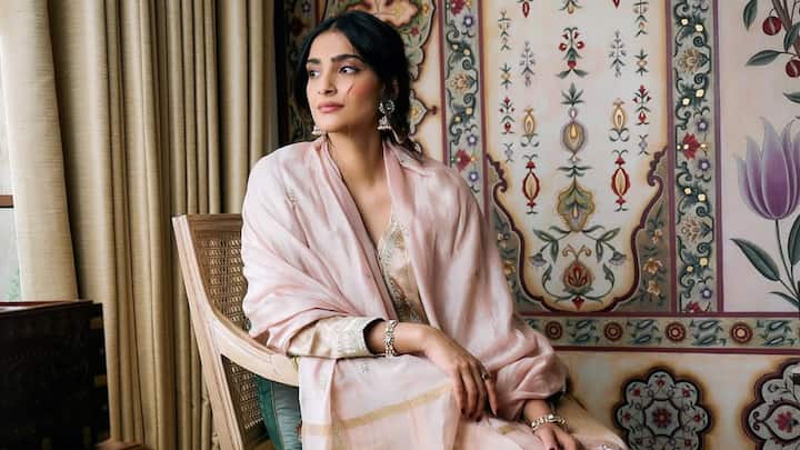 Sonam Kapoor wore an exquisite pastel pink kurta with gold trousers and a striped dupatta. The elegantly embroidered neckline and sleeves rendered the attire a royal touch, while delicate jhumkas and bangles added a flourish to an ensemble that is festive and refined – perfect for an Eid gathering. (Image Source: Instagram/ sonamkapoor)