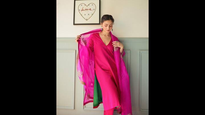 7. Charming Hot Pink Look: Alia Bhatt wore a V-neck kurta that had a simple yet striking look. She paired her striped kurta with a sheer embroidered dupatta for an elegant touch. The perfect blend of tradition and modern minimalism made the outfit ideal for special occasions. (Image Source: Pinterest/mostlyfavs)