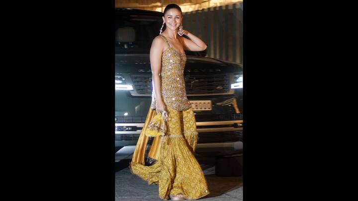 5. Heavily Embellished Mustard Look: The dazzling mustard-yellow sharara set worn by Alia Bhatt featured inticate mirror embellishments, fitted sleeveless kurta, and a flared bottom. The actress paired her ethnic look with a matching dupatta and a statement purse that gave regal elegance. (Image Source: Pinterest/vogueindia)