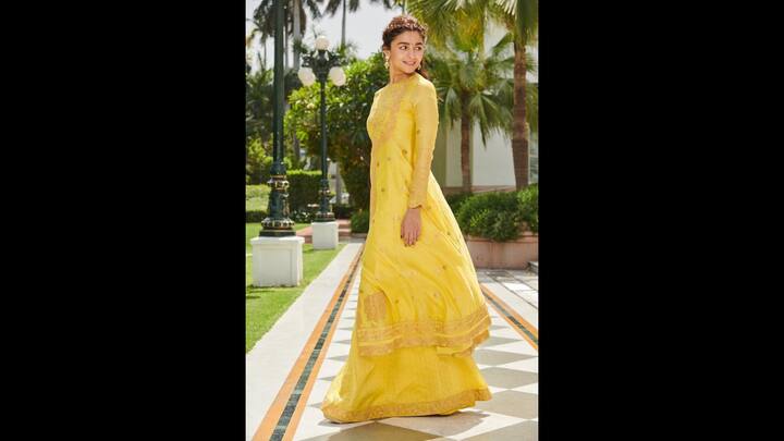 2. Radiant Yellow Ensemble: Alia wore a vibrant yellow outfit that featured a high nech long kurti with full sleeves and a flared skirt. The intricately embroidered ethnic look radiated elegance. The outfit had a traditional appeal that made the actress look charming. (Image Source: Instagram/@aliaabhatt)
