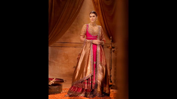 6. Regal Gold And Pink Sharara Set: This mesmerising blend of gold and pink sharara set featured intricate embroidery and luxurious fabric. Kriti Sanon wore an embellished blouse and a luxurious dupatta to enhance her look. She accessorised her look with traditional jewellery that completed the royal aesthetic. (Image Source: Instagram/@kritisanon)