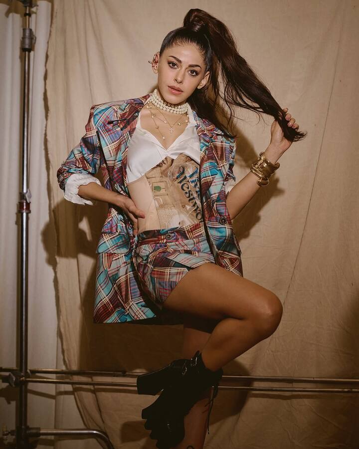 Her accessories were an eclectic mix of punk and classic glam. A stack of gold bangles adorned her wrist, while statement rings and layered pearl and gold necklaces added a touch of vintage luxury.