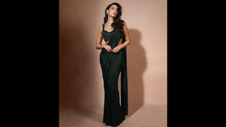 8. Nora Fatehi: Nora Fatehi wore a deep emerald saree that was adorned with shimmering sequins detailing. She paired her ethnic look with a matching heavily embellished blouse. The actress blended modern allure with classic sophistication which made the outfit perfect for the Navratri celebrations. (Image Source: Pinterest/k95asim)