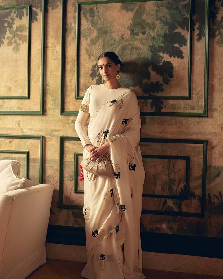 सोनम कपूर की स्टाइलिस्ट रिया कपूर ने हाल ही में इवेंट से एक्ट्रेस के लुक की फोटोज इंस्टाग्राम पर शेयर की हैं. उनकी ऑफ व्हाइट साड़ी पर तमिल स्क्रिप्ट प्रिंट है.