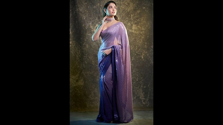 3. Tamannaah Bhatia: The shimmering dual shade purple saree had sequin detailing all over it. Tamannaah Bhatia beautifully blended glamour and tradition with this look. She wore a dual shade sleeveless blouse along her saree that seamlessly matched her fit. The actress accessorised her look with a statement choker necklace, making herself festive ready. (Image Source: Pinterest/vogueindia)