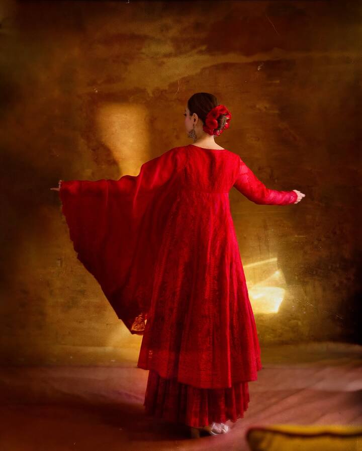 Her elegant outfit was paired with statement jhumkas, a bracelet, and her hair adorned with red roses, adding to her mesmerizing look.