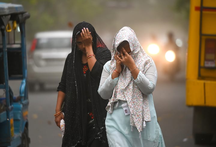 शाम के समय आंधी चलने से सड़क पर मौजूद लोगों को अपने चेहरे ढकने पड़े.