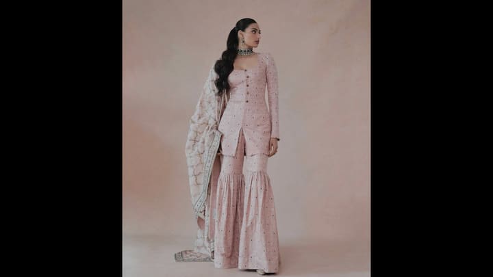 4. Athiya Shetty: Athiya Shetty wore a pink gharara set that seamlessly blended tradition with modern flair. Her fitted and full sleeved kurti had button detailing which she paired with an embroidered dupatta. Her graceful and stylish outfit is ideal for puja ceremonies and special occasions. (Image Source: Instagram/@athiyashetty)
