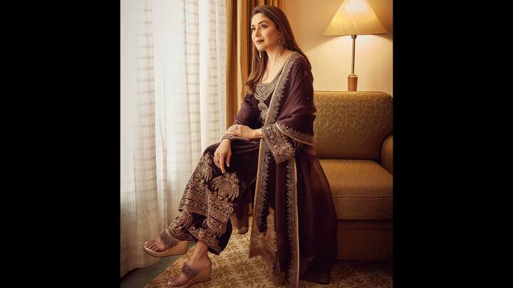 1. Madhuri Dixit: Madhuri wore a wine coloured velvet dupatta set that made her look luxurious. The outfit had golden zari work that added elegance. She paired her suit set with a matching dupatta for a timeless and festive beauty. (Image Source: Instagram/@madhuridixitnene)