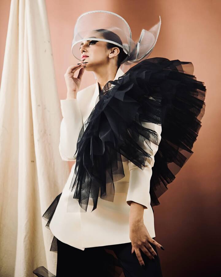 The standout feature of the ensemble is the voluminous black frills that cascade across the shoulder and waist.