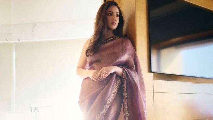 Yami Gautam exudes glamour as she donned this plum-hued saree, sporting a precise scallop border and out of it sparkling golden embroidery; this look is perfect for both traditional functions and get-togethers. (Image Source: Instagram/ yamigautam)