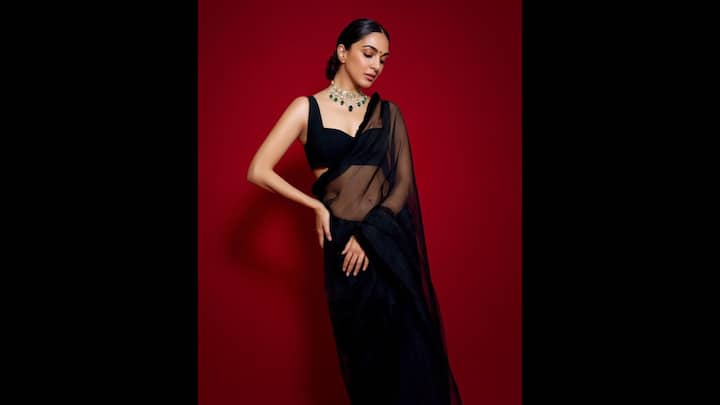 1. Bold Black Saree: Kiara Advani stunned in a sheer black saree that she paired with a sleek black blouse. The actress elevated her outfit with a statement choker necklace. She served a graceful look in here monochromatic traditional attire. (Image Source: Twitter/@jsolu_tions)