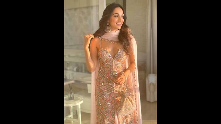 8. Mirror Work Suit: Kiara Advani wore a pastel hued suit that mirror detailing, delicate embellishments, and intricate embroidery work. The actress styled her look with big statement earrings that radiated elegance and charm. She wore a sheer pink dupatta with delicate seashell detailing that matched her pastel traditional look. (Image Source: Twitter/@Jatin150Kumar)