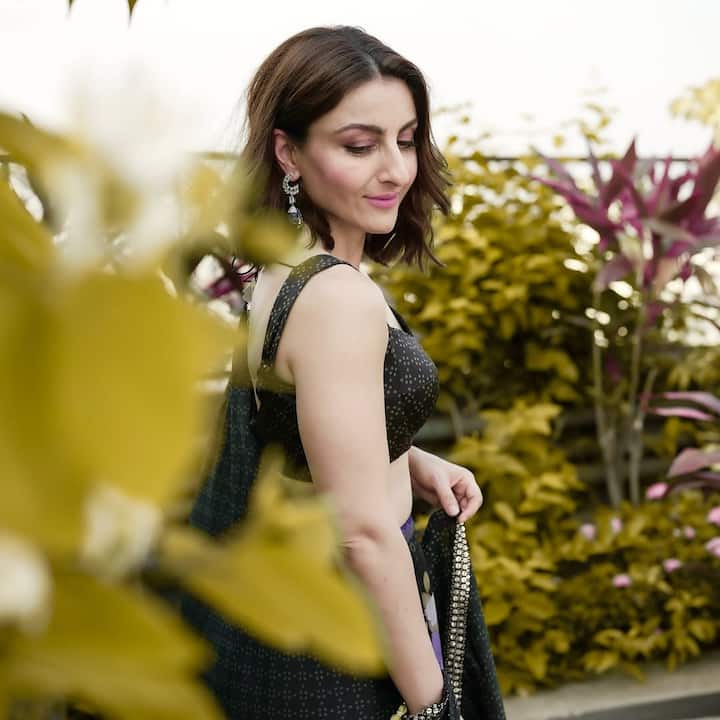 Soha accessorized with stunning statement earrings from Niramya Jewels — bold, drop-style earrings featuring deep blue stones, which added a vibrant pop of color to her monochrome outfit. She kept the rest of her accessories minimal, allowing the earrings to shine as the statement piece of her look.