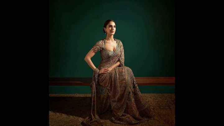 4. Regal Saree Look: Vaani Kapoor stunned in an intricately embroidered saree that gave her a regal vibe. She enhanced her look with a heavily beaded and embroidered blouse that had a plunging neckline. The tones and fabric of her attire exuded grace and made her look poise. Her ethnic outfit had a vintage royal elegance, making it perfect for puja gatherings. (Image Source: Instagram/@vaanikapoor)