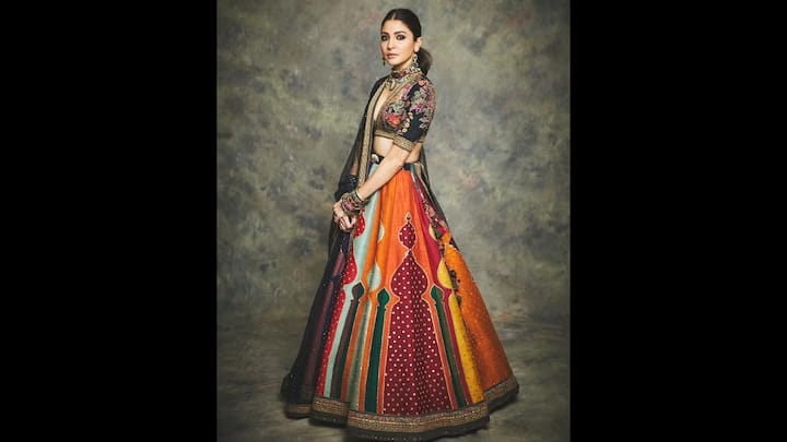 7. Vibrant Multicoloured Lehenga: Anushka Sharma looked flawless in her multicoloured lehenga. Her outfit consisted of a dark coloured floral blouse and a matching coloured sheer dupatta. The lehenga had delicate lace detailing on it take added a regal vibe. She completed her ethnic look with multicoloured statement jewellery, making the attire ideal for festive celebrations and weddings. (Image Source: Instagram/@anushkasharma)