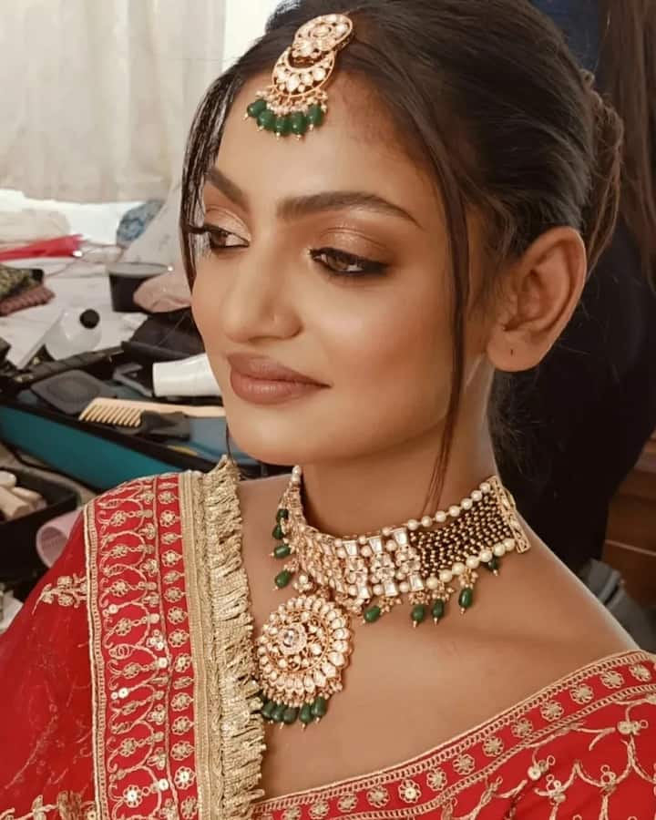 मोनालिसा ने अपना ब्राइडल लुक बालों में जुड़ा, सेटल मेकअप और ग्रीन कलर की हैवी ज्वैलरी के साथ कंपलीट किया है.