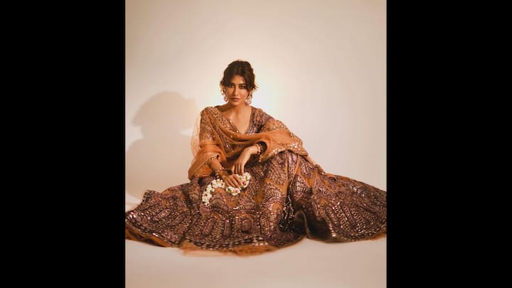 4. Royal Lehenga Look: The brown and bronze lehenga featured intricate sequin work and was richly embellished. Chitrandga Singh wore a matching sheer dupatta that had beautiful mirror work along the borders. To elevate her regal look, the actress opted for heavy traditional earrings and bangles. (Image Source: Instagram/@chitrangda)