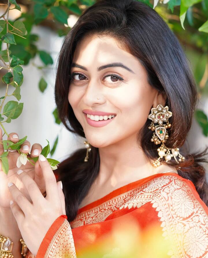 Falaq is seen donning a rich orange silk saree adorned with intricate golden zari work. The saree, from the label Rasm by Muskaan, showcases an exquisite border featuring traditional Indian motifs, striking a perfect balance between regal and festive.