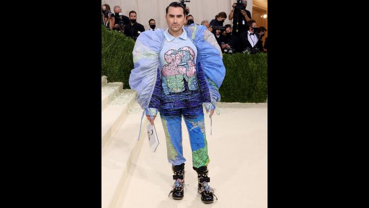 8. Dan Levy: Dan Levy's 2021 Met Gala outfit was a deeply meaningful fashion statement that combined art. He wore matching trousers and shirt that had a voluminous sleeves. The shirt depicted two men kissing, an artwork by Wojnarowicz. He paired his look with black boots that were adoned with floral embellishments and silver buckles.  (Image Source: Instagram/@trimqueen)