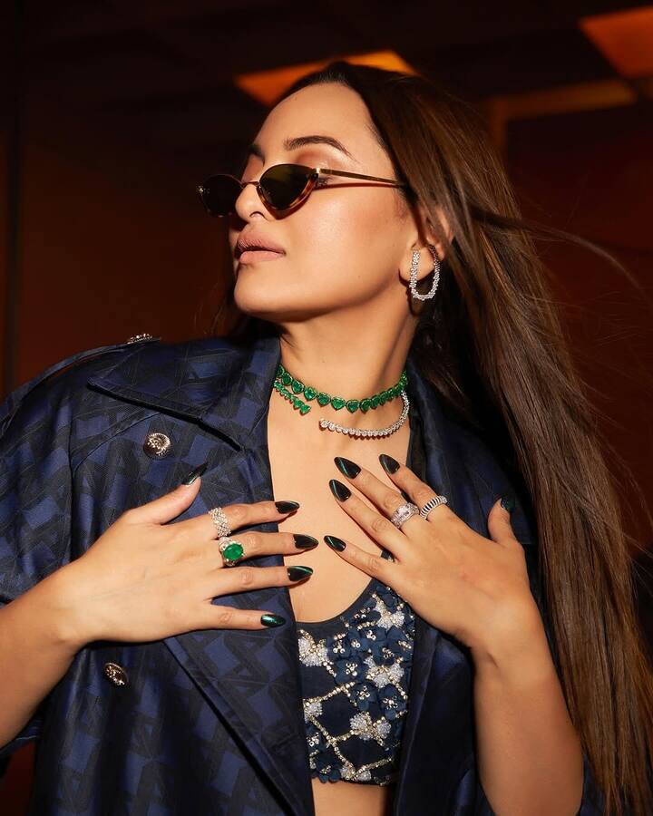 The layered green emerald and diamond choker added a bold pop of colour to her deep-toned outfit, along with matching rings and sparkly hoop earrings.