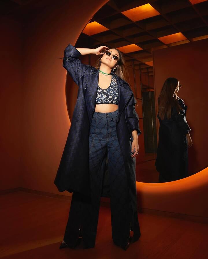 She wore a striking three-piece co-ord set from Falguni Shane Peacock India, featuring a structured oversized navy trench coat with subtle textured patterns, paired with matching flared trousers and a heavily embellished crop top. The intricately beaded top added a dose of shimmer and contrast, balancing edgy and elegant seamlessly.