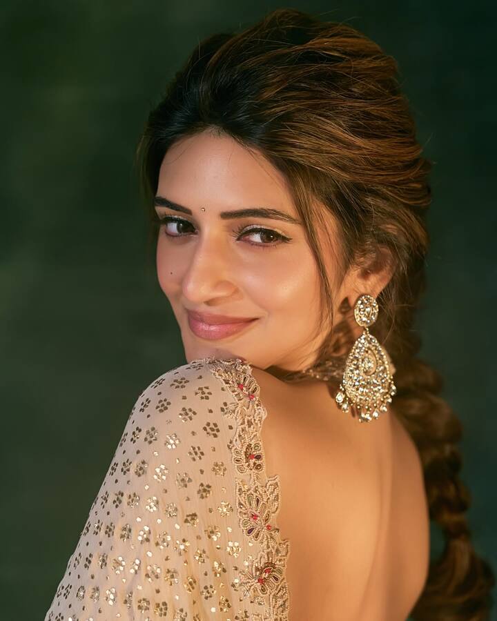 She sported a braided hairstyle with a voluminous puff, and the front strands were tossed in loose waves.