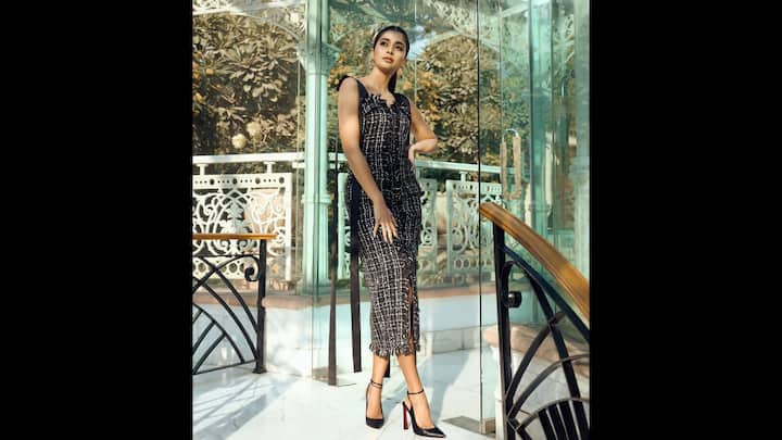 4. Black And White Tweed Dress: Pooja Hegde wore a sleeveless and fitted back and white tweed dress. The ankle length dress had delicate fringed hem and classic stilettos that created a timeless look. The actress paired her look with classic and dainty accessories. (Image Source: Instagram/@hegdepooja)