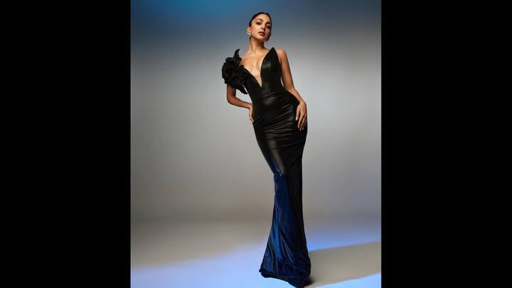 1. Black Glam: Kiara Advani served a glamorous look in her sleek black gown. The outfit featured a plunging neckline and a dramatic floral shoulder detailing. The body hugging outfit enhanced her look. The actress opted for minimal accessories to keep her outfit the center of attention. (Image Source: Instagram/@kiaraaliaadvani)