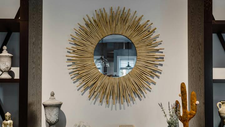 5. Glass and Mirror Elements: Glass and mirrors are timeless decor items as they create an illusionary effect which creates the illusion of spaciousness in a room and also brings brightness too. A large mirror reflects natural lighting, making a room seem larger, while a coffee table with a glass top provides an airy feel without overwhelming the space of the living area or any other room. These pieces blend with any style while fostering a balanced, open atmosphere.  (Image Source: Canva)