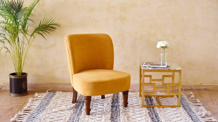 4. Accent Chairs and Statement Pieces: A single impactful design element is sometimes all that is needed to lift a room. Accent chairs featuring eye-popping textures, patterns, or even sculptural shapes can serve as the centerpiece of a room, or space. Be it an aged leather piece or a more modern sculptural chair, these statement chairs are characterful and charming. Coupled with thoughtful styling, such as a decorative lamp or art, these chairs have the power to effortlessly transform a space.  (Image Source: Canva)